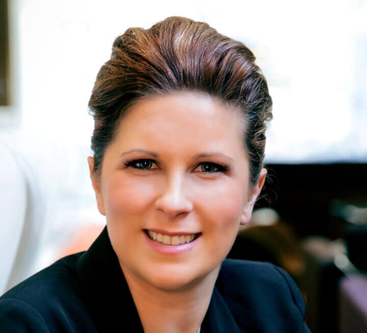 Woman in black jacket smiling facing front