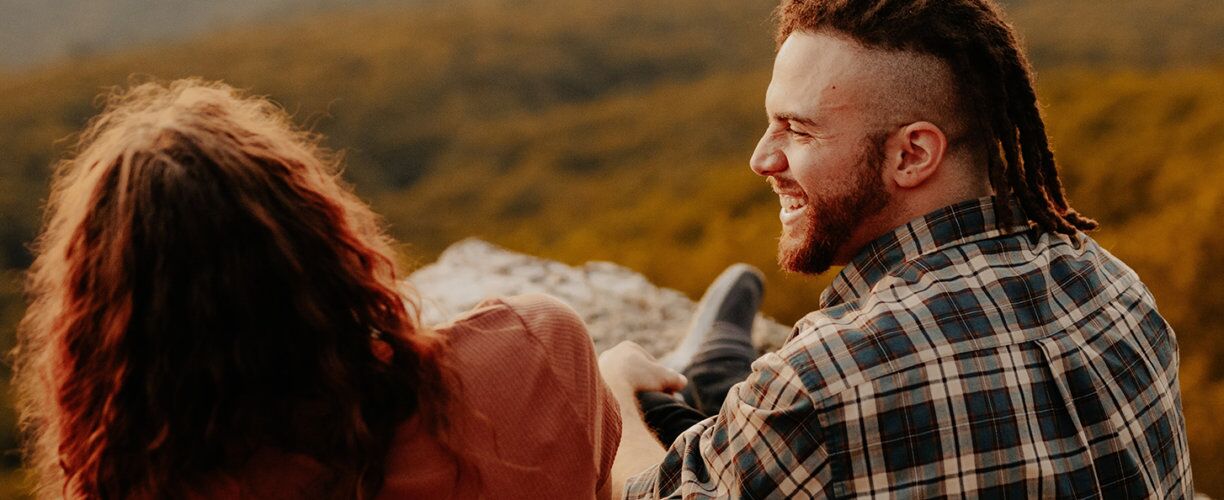 Two people laughing at dusk outside