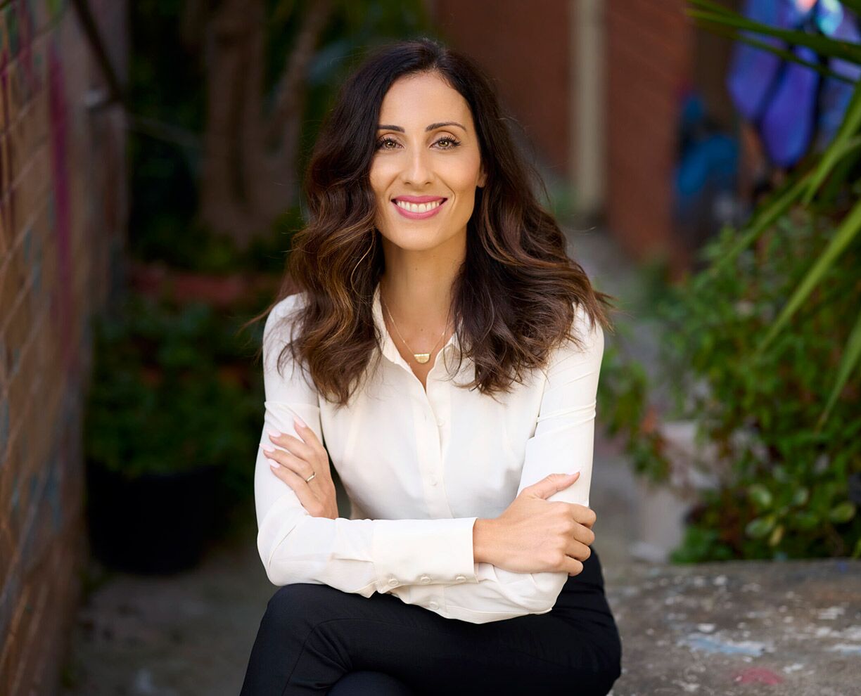 Photo of GDLP course leader Desi Vlahos sitting with her legs and arms crossed