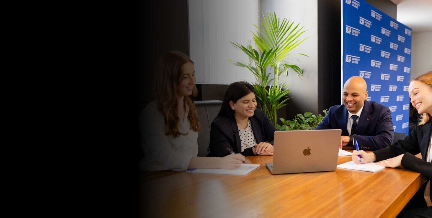 Four Law (PLT) students from ACAP University in Melbourne sitting around a desk in front of notepads and a laptop (2880x1188)